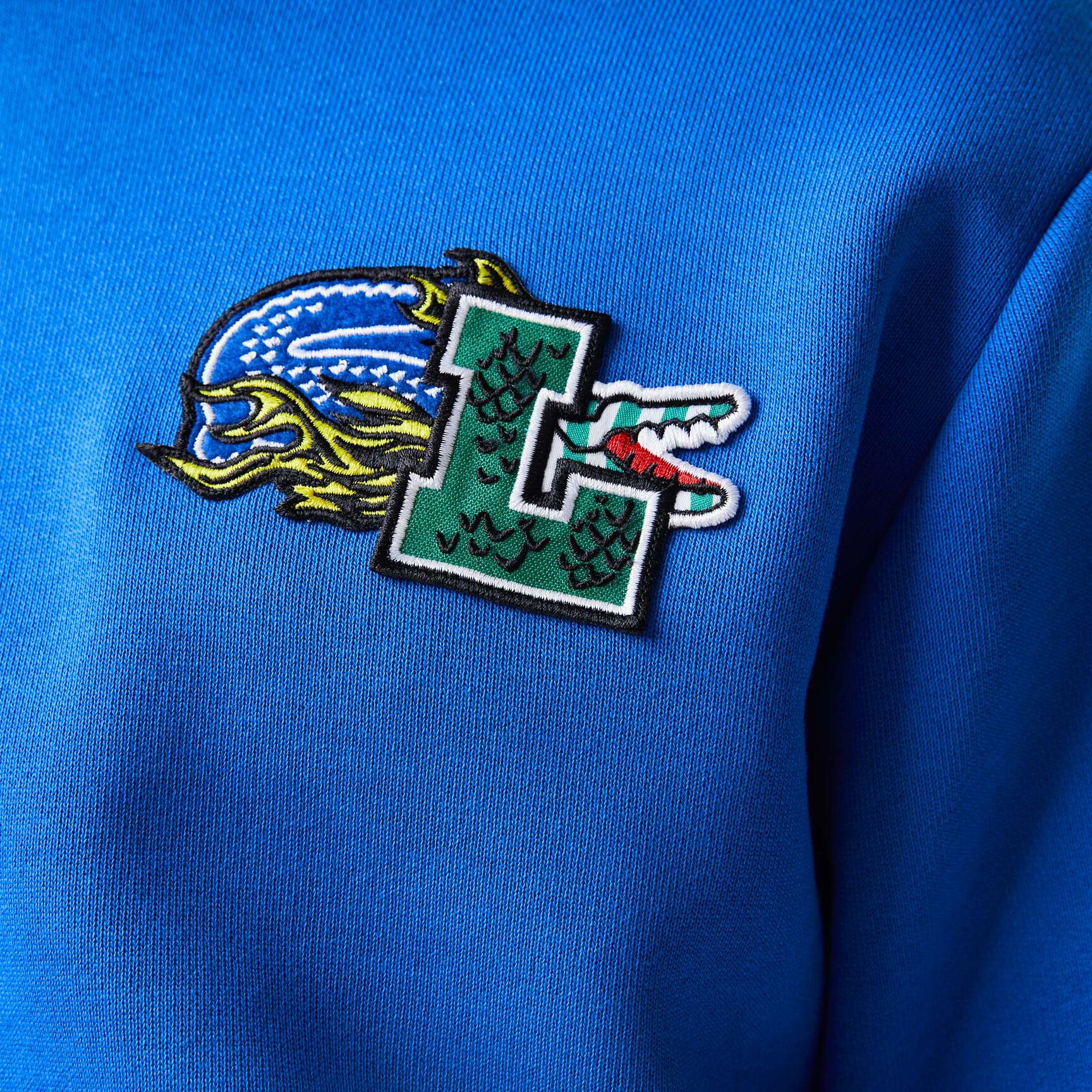 سويت شيرت بغطاء رأس لاكوست بنقشة قصص مصورة من تشكيلة موسم الأعياد للرجال